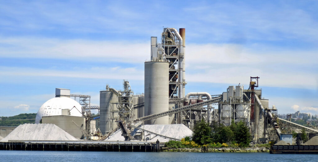 A specialized bulk carrier vessel actively loading premium industrial grade cement clinker via automated port logistics.